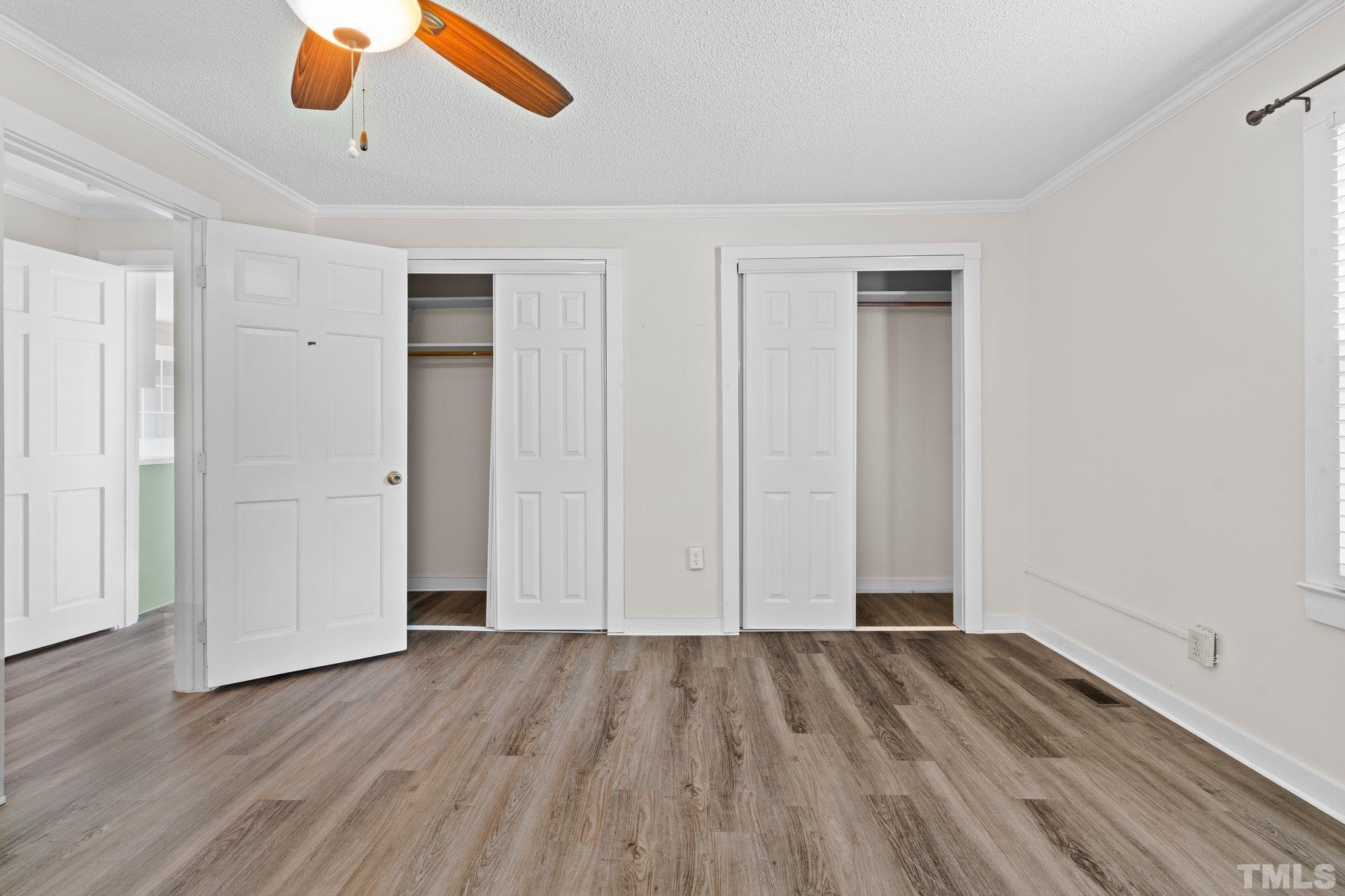 2929 Wall Store Road Garner, NC 27529 - Photo 13 of 59 an empty room with wooden floor cabinet and windows