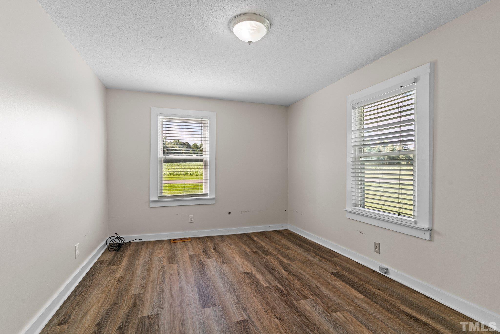 2929 Wall Store Road Garner, NC 27529 - Photo 22 of 59 an empty room with wooden floor and windows