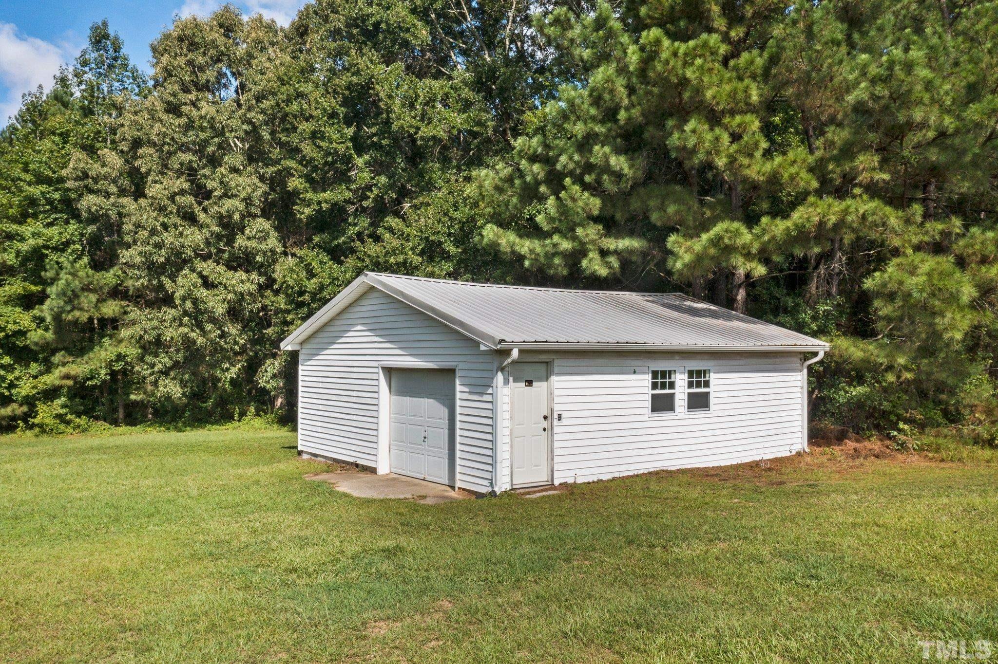 2929 Wall Store Road Garner, NC 27529 - Photo 47 of 59 a backyard of a house with plants and large tree