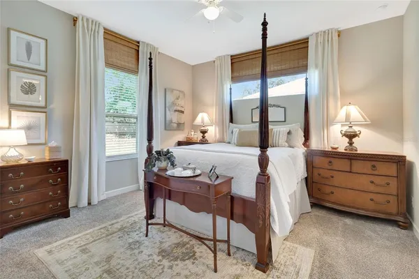 a bedroom with a bed and large windows