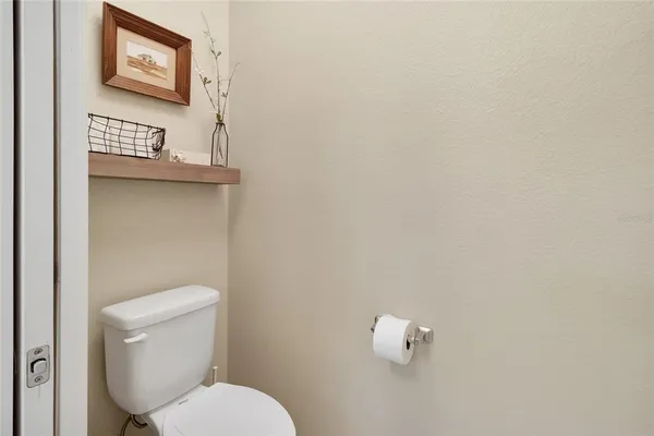 a white toilet sitting next to a white wall