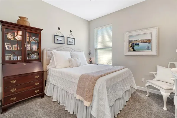 a bedroom with a bed and a lamp on dresser