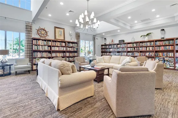 a living room with furniture a chandelier and a flat screen tv