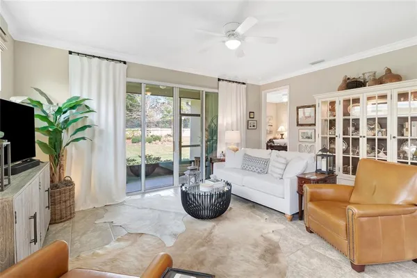 a living room with furniture a chandelier and a flat screen tv