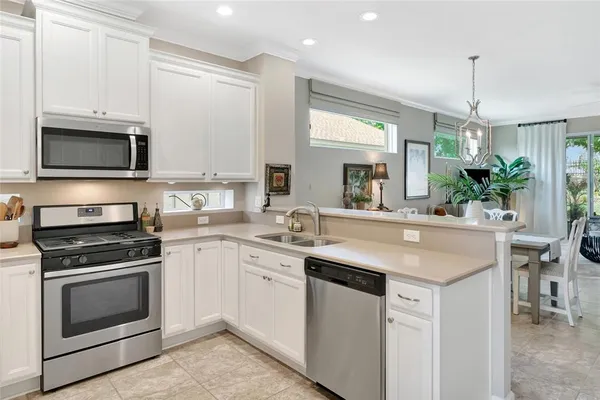 a kitchen with stainless steel appliances granite countertop a stove a sink and a microwave