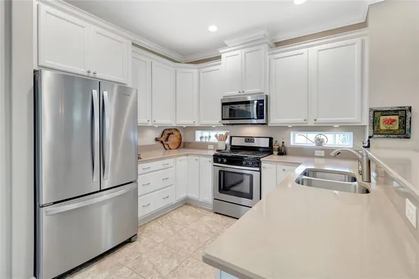 a kitchen with white cabinets and stainless steel appliances