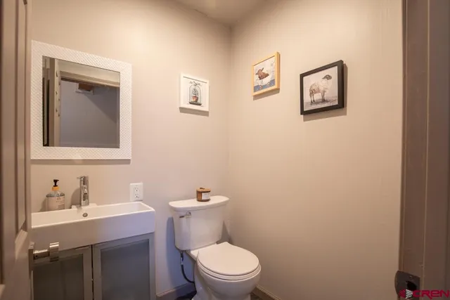 a bathroom with a toilet a sink and mirror
