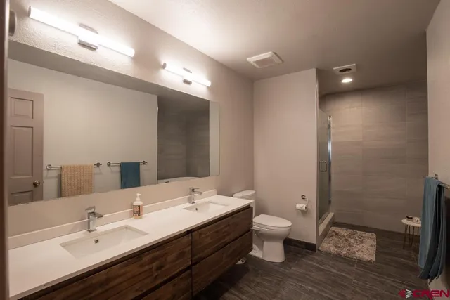 a bathroom with a double vanity sink toilet and shower