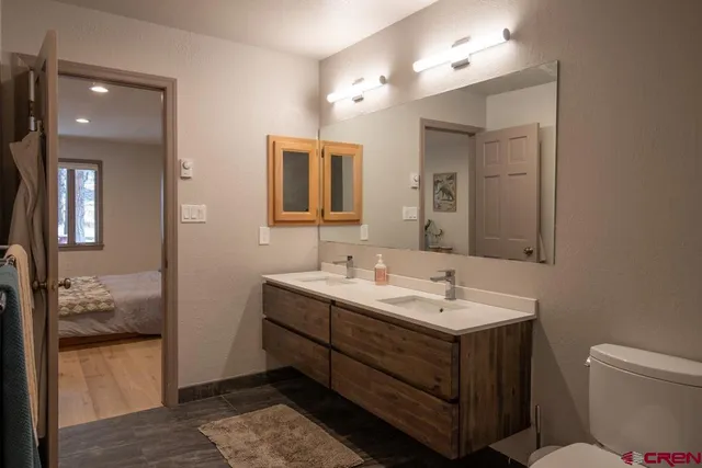 a bathroom with a toilet sink and mirror