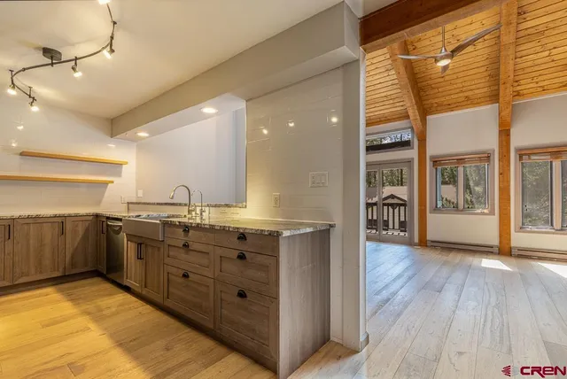 a kitchen with granite countertop a stove and a wooden floors