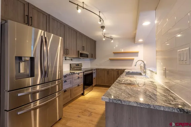 a kitchen with granite countertop a refrigerator and a sink