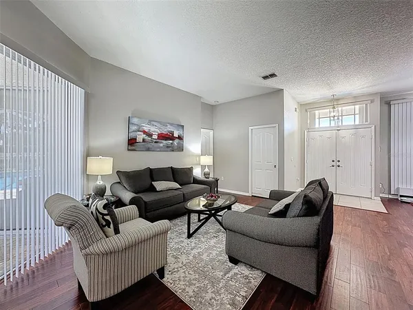 a kitchen with granite countertop a table chairs microwave and cabinets
