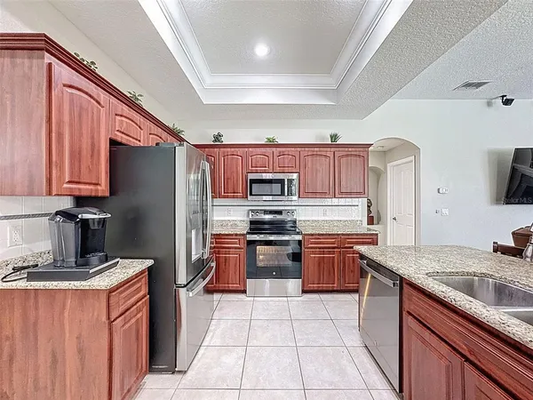 a living room with furniture kitchen view and a wooden floor