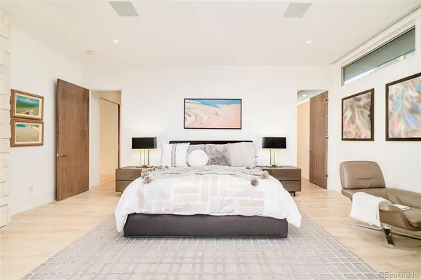 a spacious bedroom with a bed and glass chair