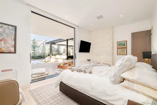 a large bedroom with a bed and glass window