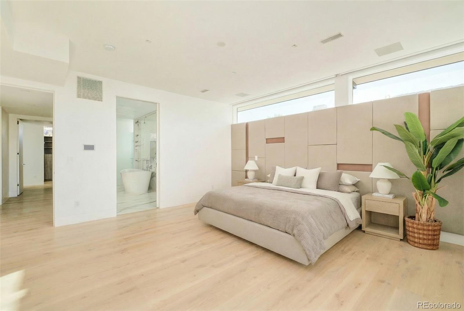 121 South Dexter Street Denver, CO 80246 - Photo 29 of 42 a spacious bedroom with a bed and a potted plant