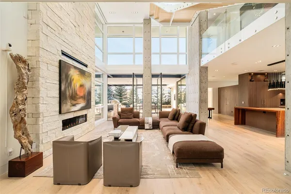 a living room with couches a flat screen tv and kitchen view