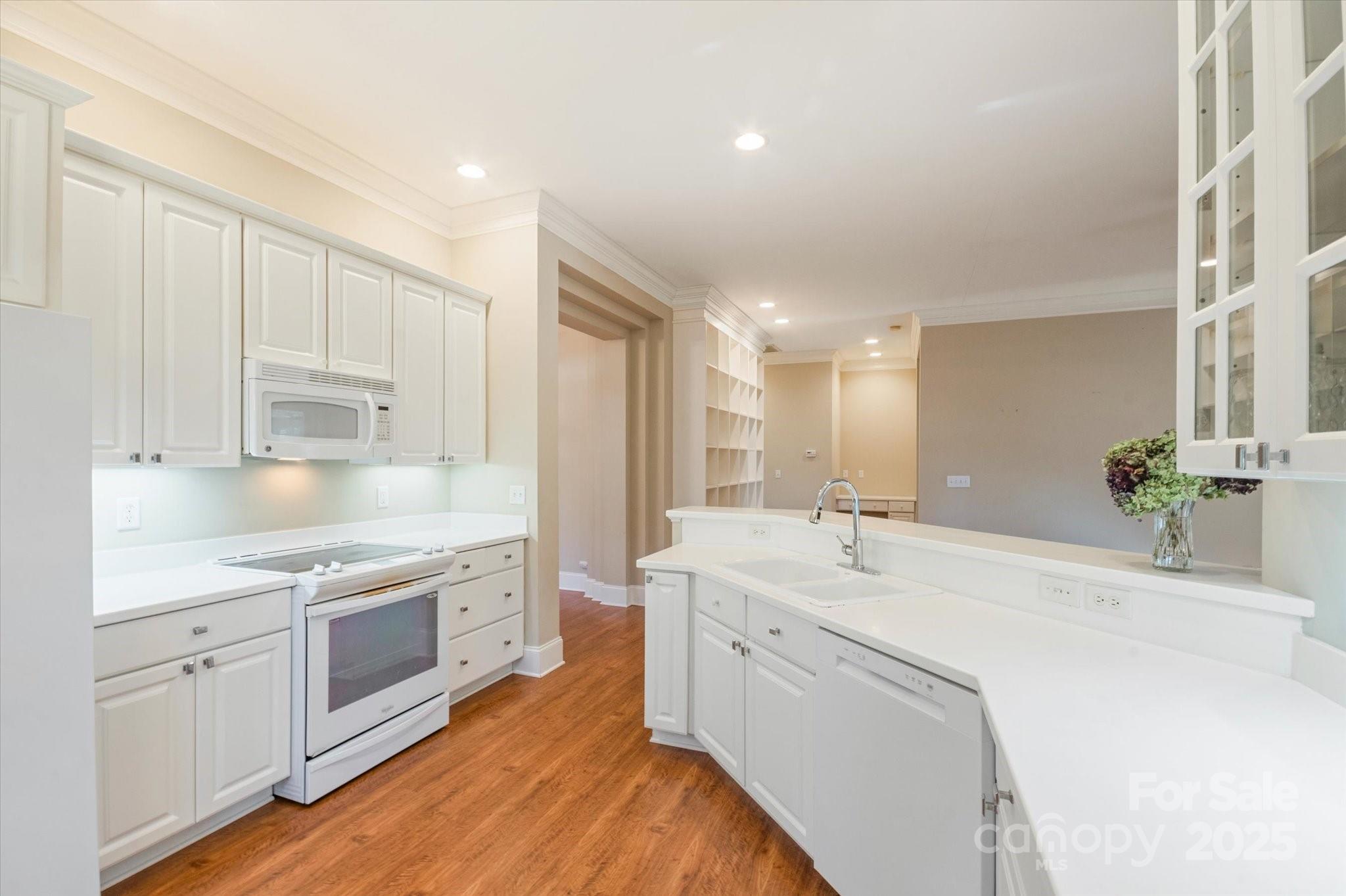 186 Camptown Road Brevard, NC 28712 - Photo 17 of 38 a large white kitchen with a stove a sink a refrigerator and white cabinets with wooden floor