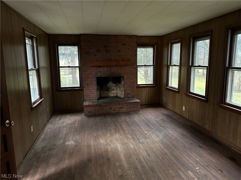 16055 Old State Road Middlefield, OH 44062 - Photo 9 of 12 Unfurnished living room featuring a fireplace, plenty of natural light, and dark wood-style flooring