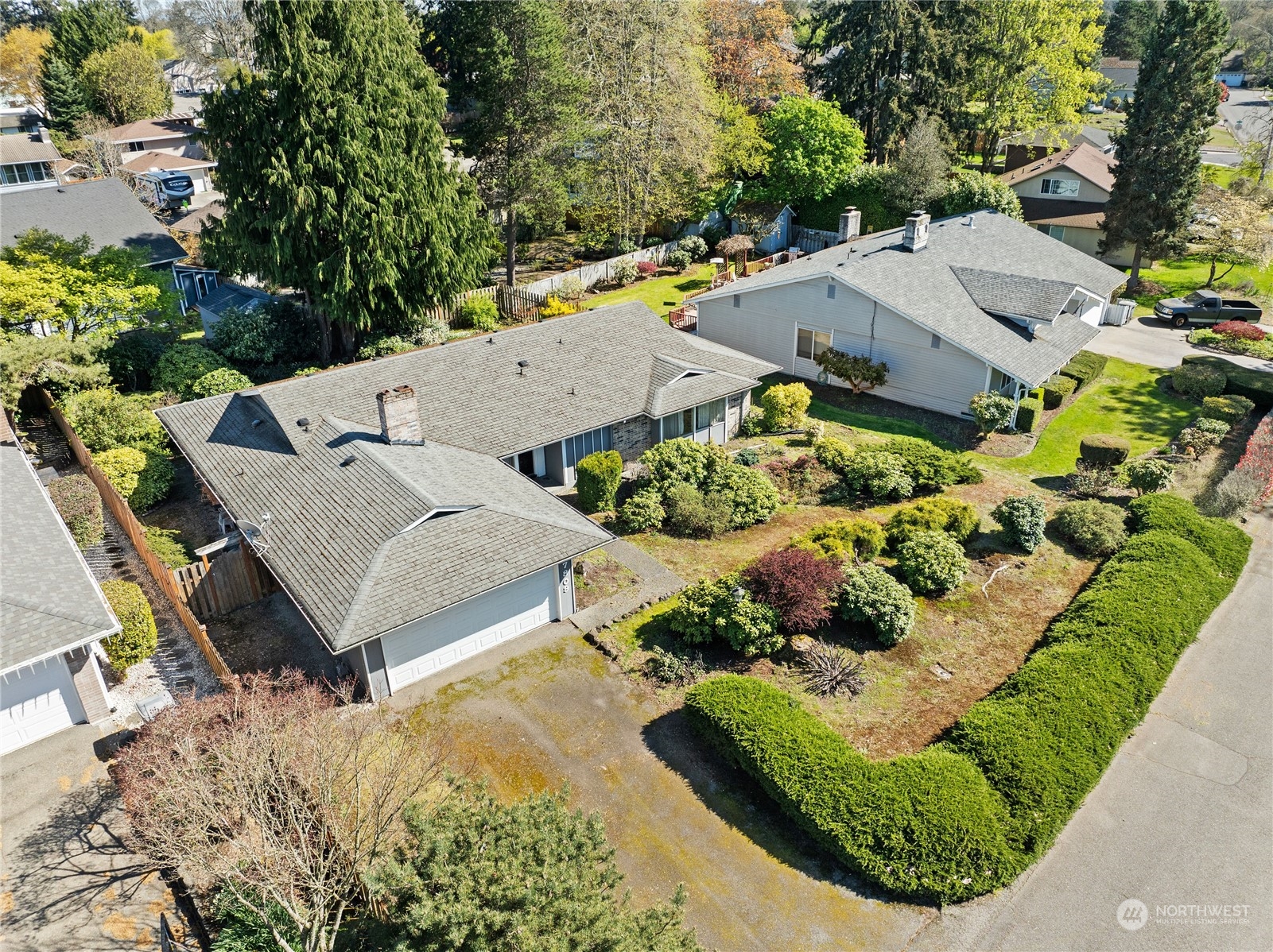 an aerial view of a house with a yard and greenery