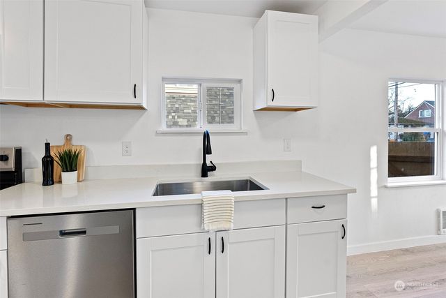 a kitchen with white cabinets and a sink