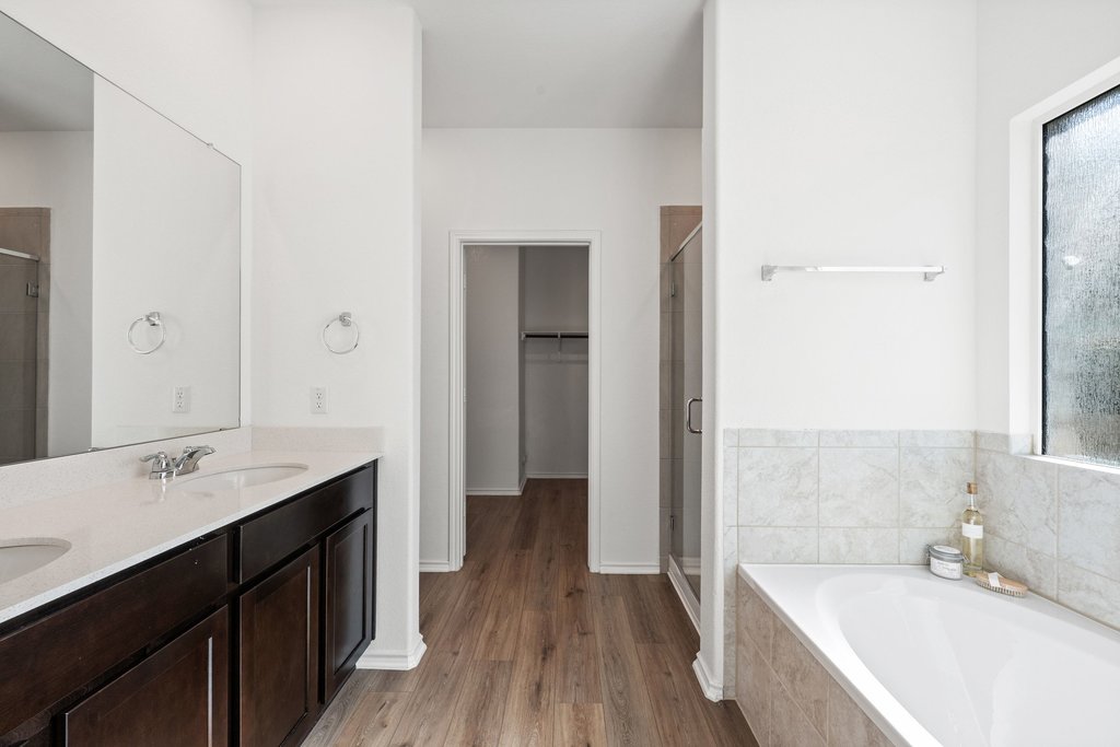 1233 Sweetspire Street Leander, TX 78641 - Photo 15 of 40 The primary bath features dual vanities, a walk-in shower, soaking tub and generous walk-in closet.