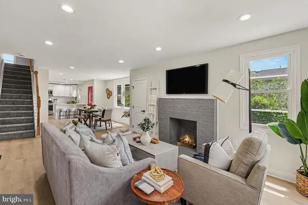 a living room with furniture a fireplace and a flat screen tv
