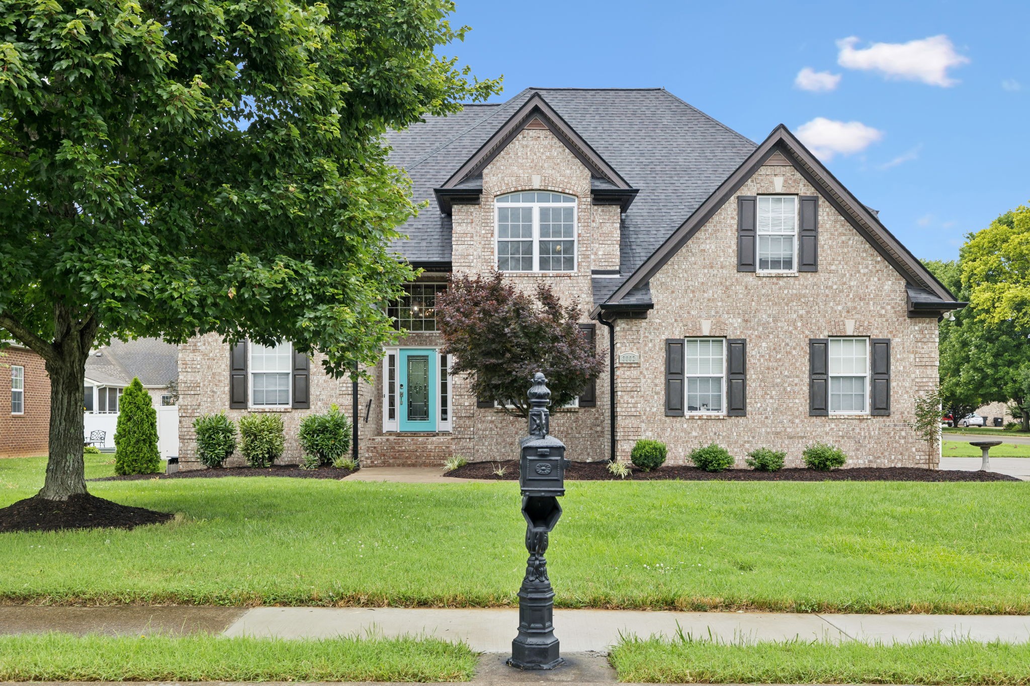 a front view of a house with a garden and yard