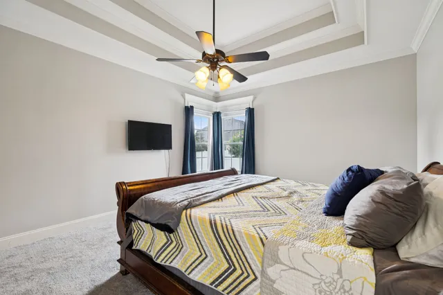 an empty room with a chandelier fan and view of bathroom