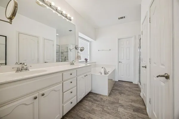 a spacious bathroom with double sink and a large mirror