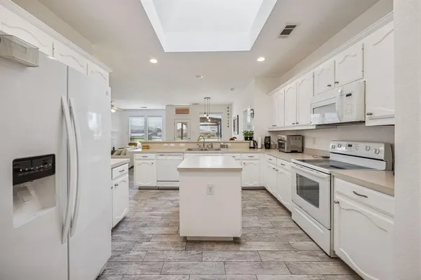 a kitchen with white cabinets and white appliances