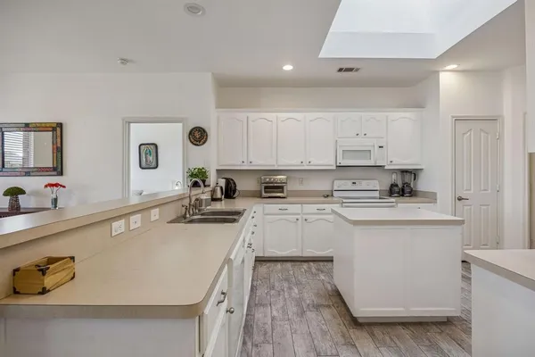 a kitchen with stainless steel appliances granite countertop a sink a stove and cabinets