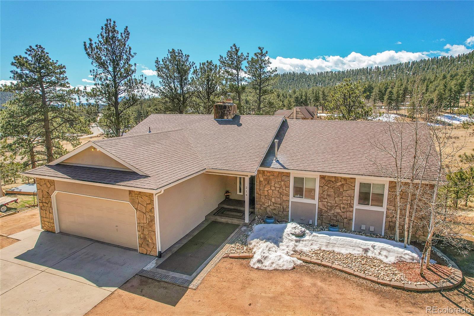 214 Conestoga Road Bailey, CO 80421 - Photo 1 of 30 a view of a white house with a yard and sitting area