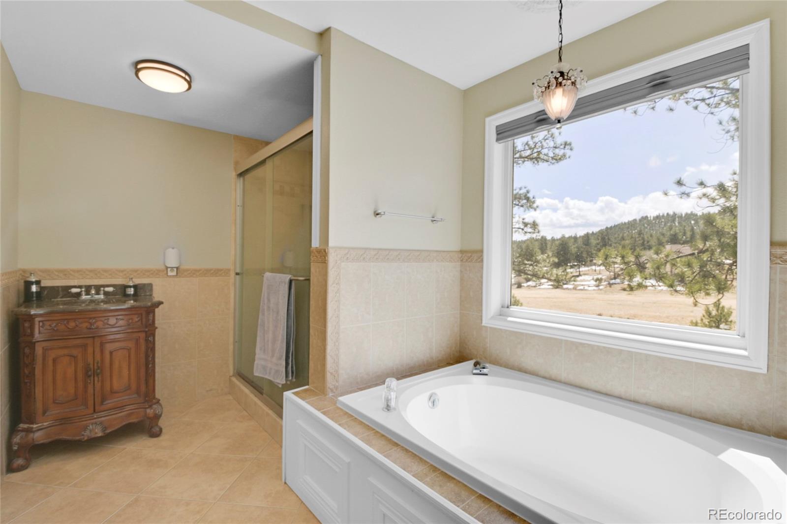 214 Conestoga Road Bailey, CO 80421 - Photo 15 of 30 a bathroom with a tub sink and a mirror