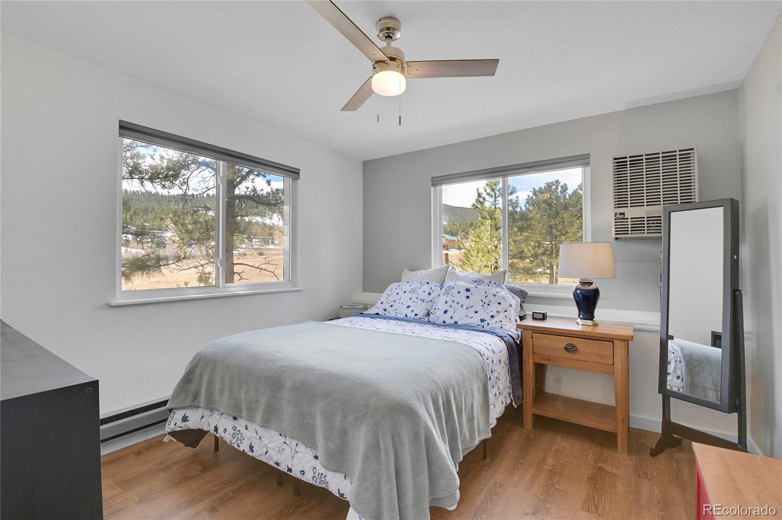 214 Conestoga Road Bailey, CO 80421 - Photo 19 of 30 a bedroom with a bed and a desk next to a window