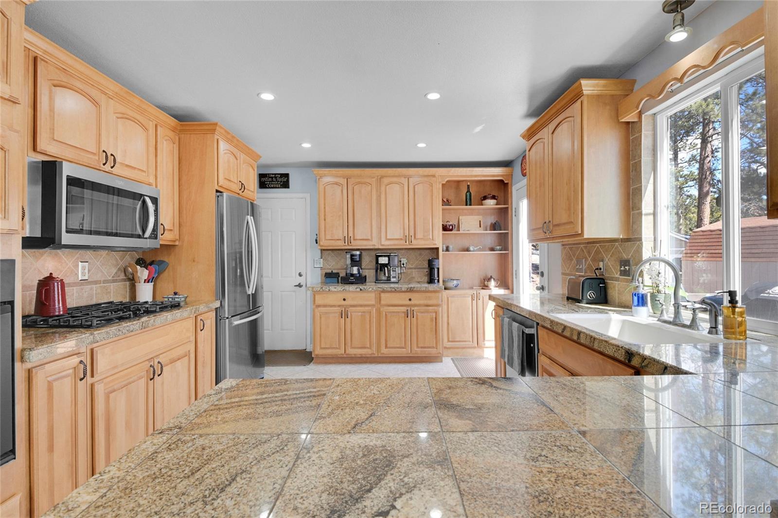 214 Conestoga Road Bailey, CO 80421 - Photo 9 of 30 a large kitchen with stainless steel appliances granite countertop a stove a sink dishwasher a refrigerator and cabinets with wooden floor