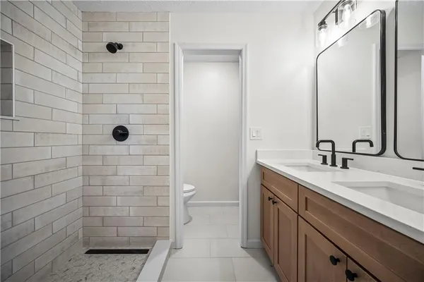 a bathroom with a sink a toilet and shower