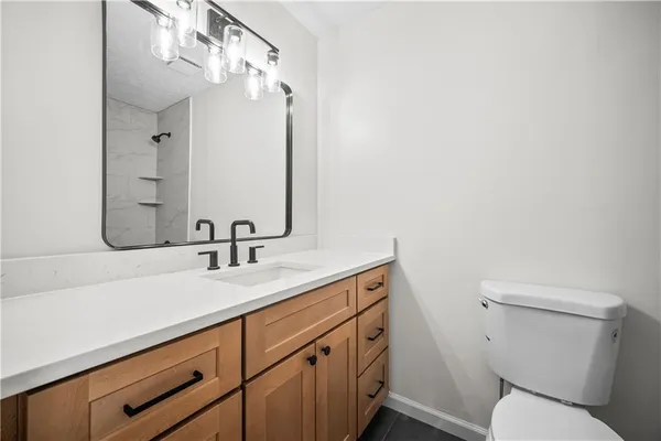 a bathroom with a sink a toilet and mirror