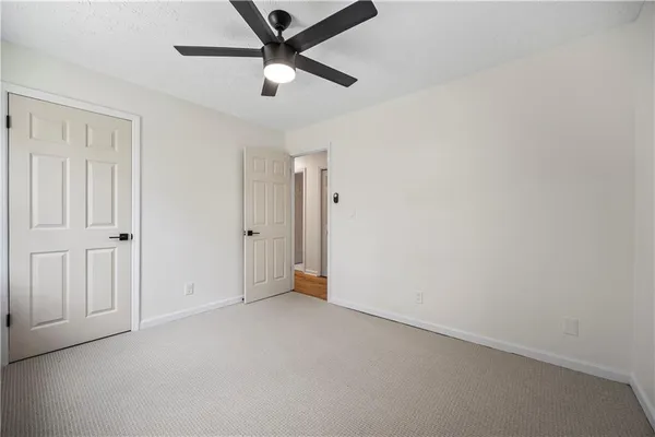an empty room with closet and fan