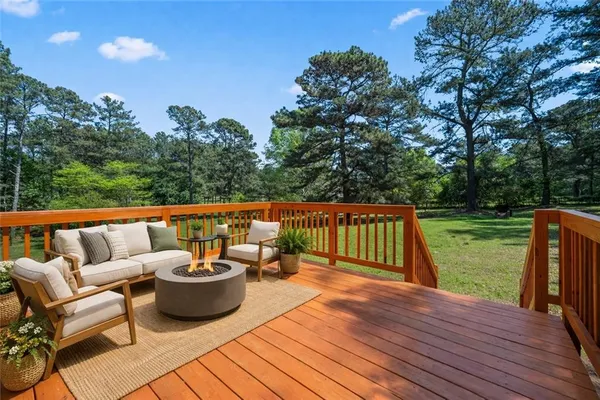 a balcony with wooden floor and outdoor seating