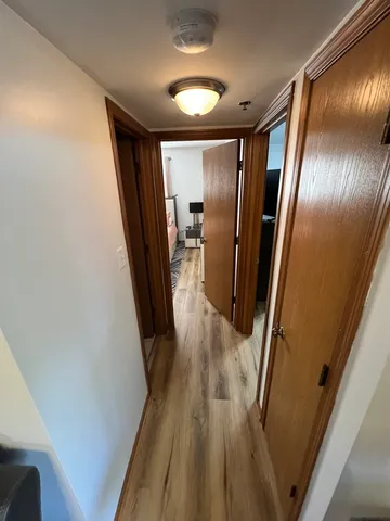 a view of a hallway with wooden floor and staircase