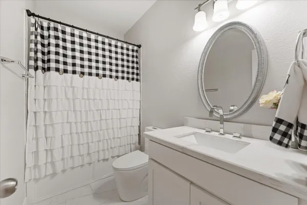 a bathroom with a sink a toilet and a mirror