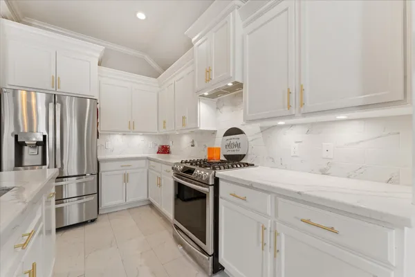 a kitchen with white cabinets and white appliances