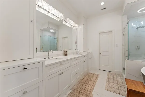 a spacious bathroom with 2 sink and a mirror