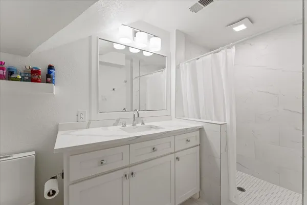 a bathroom with a granite countertop sink and a mirror