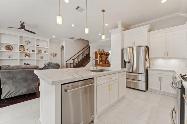 a kitchen with stainless steel appliances kitchen island a refrigerator sink and cabinets
