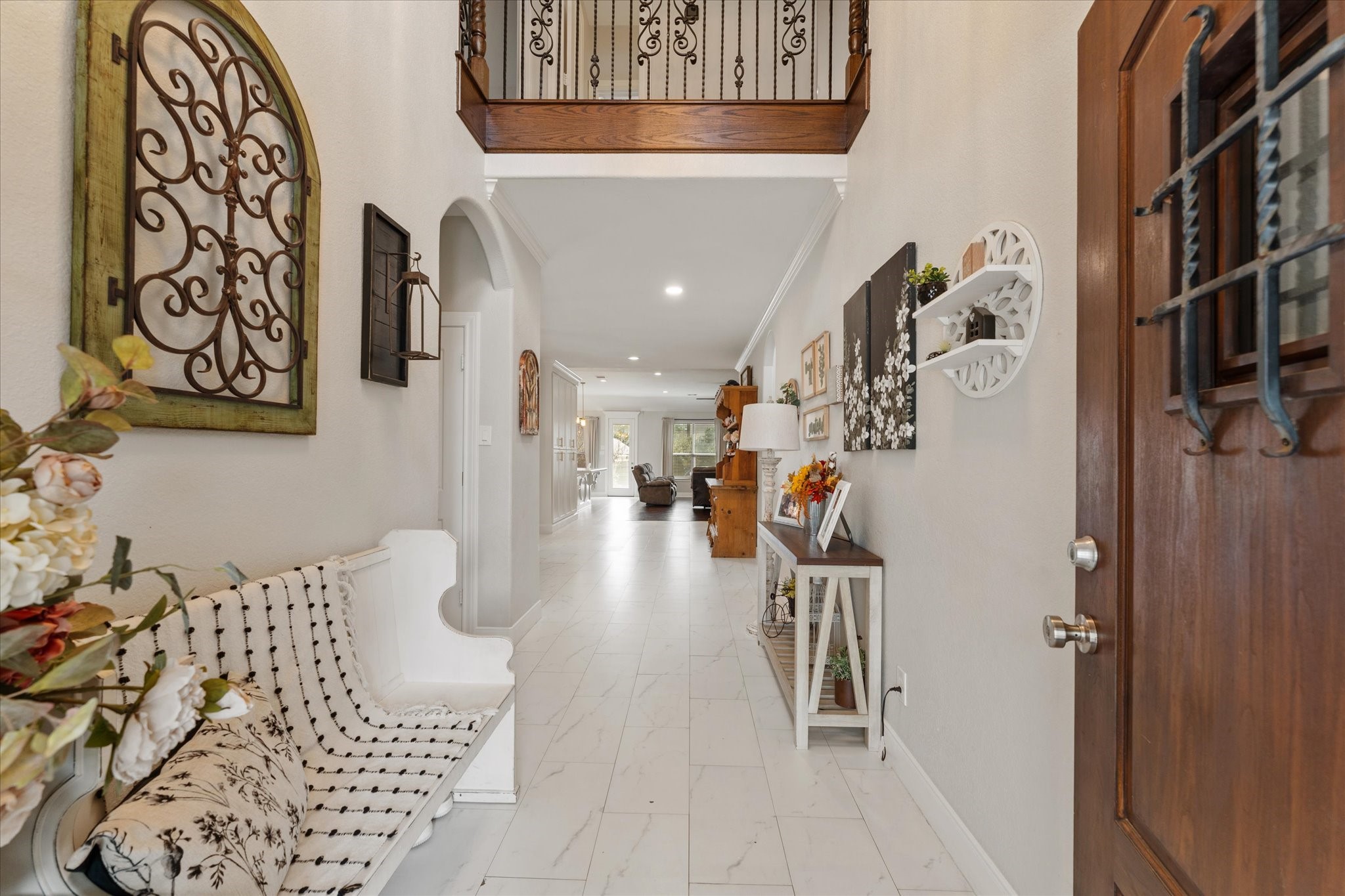 1706 Elmside Court Conroe, TX 77301 - Photo 8 of 37 Your guests are greeted at this entryway with Carrera style tile flooring, wrought-iron balusters, and a beautiful matching wooden speakeasy front door.
