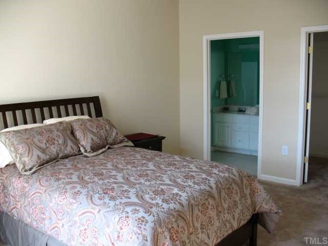 2511 Friedland Place, Unit 200 Raleigh, NC 27617 - Photo 7 of 12 a large bed sitting in a bedroom next to a bathroom