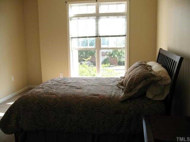 2511 Friedland Place, Unit 200 Raleigh, NC 27617 - Photo 8 of 12 a bed sitting in a bedroom next to a window