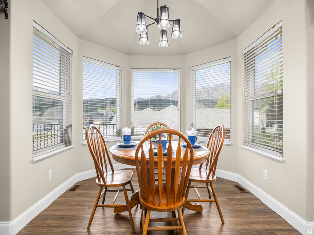 6849 North Black Powder Road Mountain Green, UT 84050 - Photo 11 of 43 Bay window dining area featuring wood-finish flooring, light neutral wall paint, and a contemporary multi-light fixture
